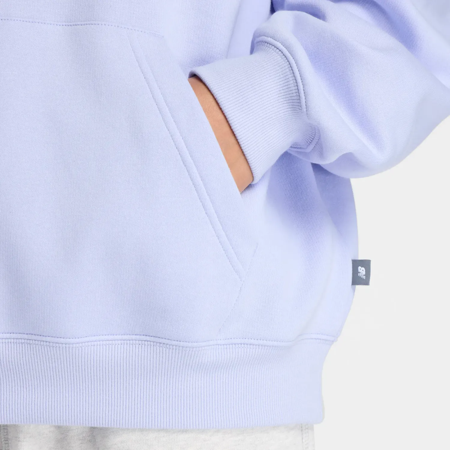 Polera New Balance Deportiva Mujer Linear Heritage Fleece Hoodie color lavanda | Platanitos
